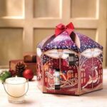 Yankee Candle Adventskalender mit geöffnetem Türchen neben brennender Kerze