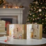 Geöffneter Yankee Candle Adventskalender mit nummerierten Fächern neben Weihnachtsbaum