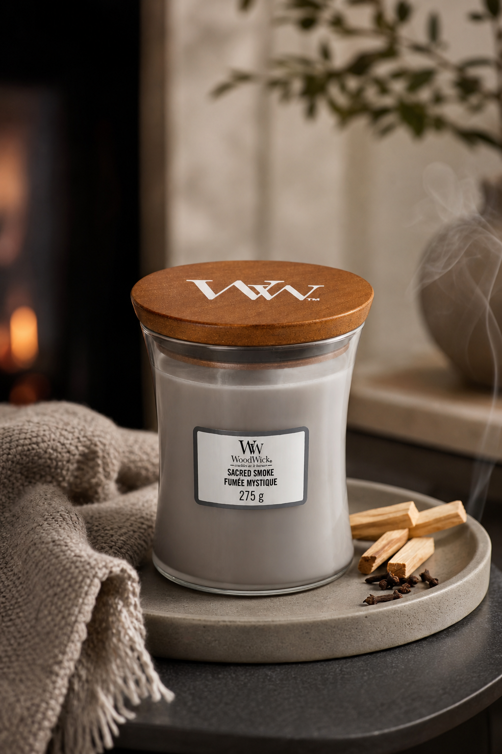 WoodWick Sacred Smoke Kerze auf Tablett neben Zimtstangen