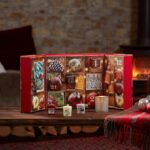 Geöffneter Adventskalender mit nummerierten Fächern und drei kleinen Kerzen