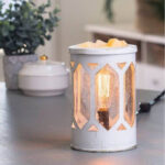 Beleuchtete Duftlampe mit Edison-Leuchtmittel und Wachsschmelze auf Möbeloberfläche