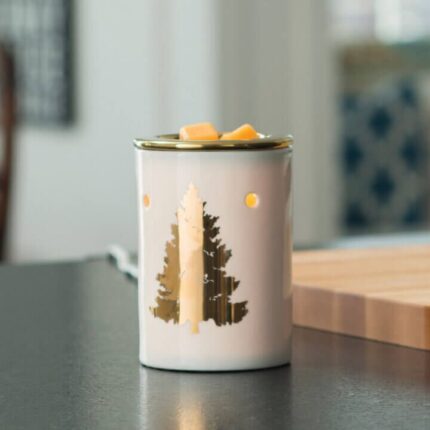 Duftlampe mit Tannenbaum-Motiv neben Blumen und gestapelten Büchern