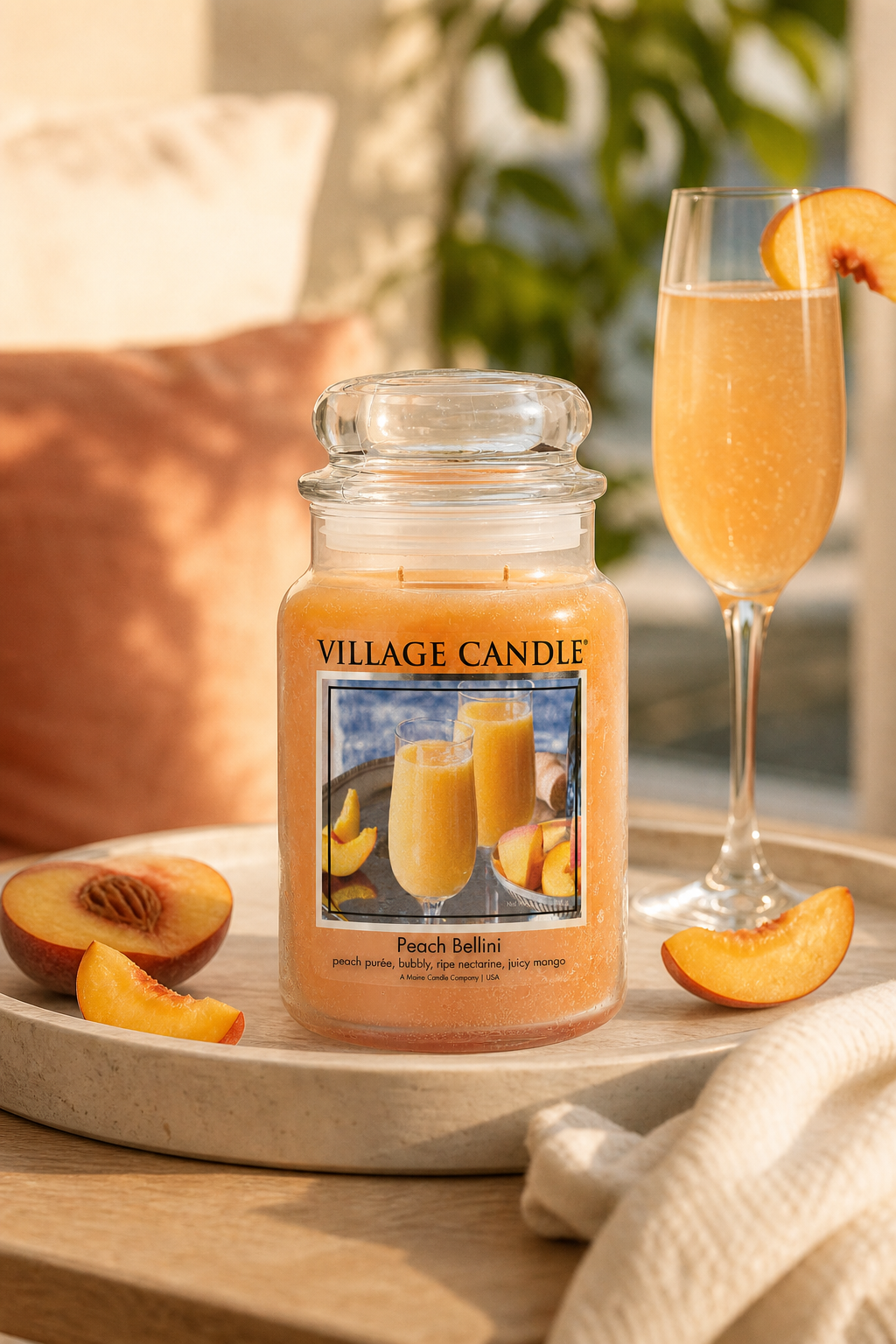 Peach Bellini Kerze neben Sektglas und Pfirsichstücken