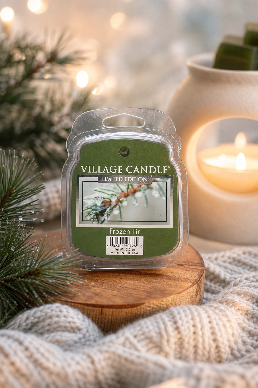 Village Candle Frozen Fir auf Holzunterlage neben einer brennenden Kerze