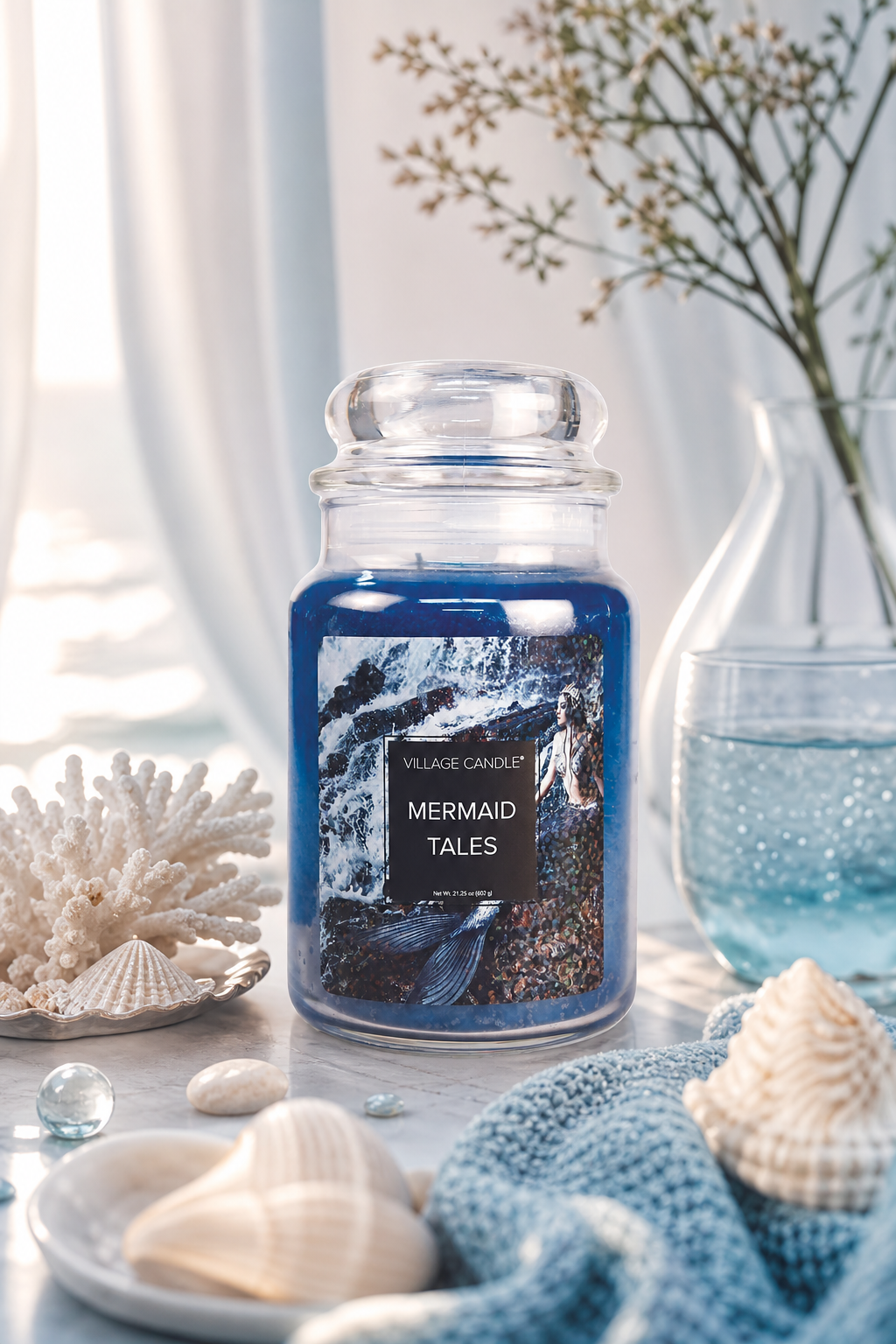Blaues Village Candle Glas zwischen Muscheln und maritimer Dekoration