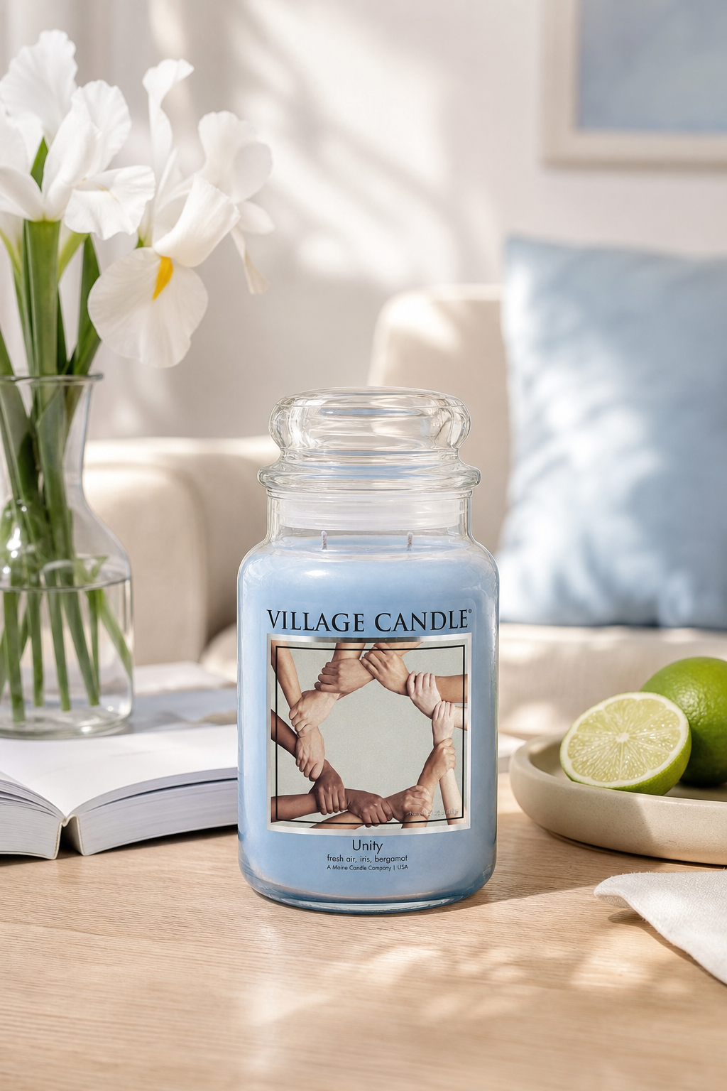 Village Candle Unity Kerze auf Tisch neben Blumen, Buch und Limetten