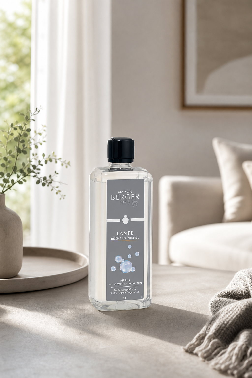 Maison Berger Air Pur Nachfüllflasche steht auf einem Tisch neben Sofa und Vase