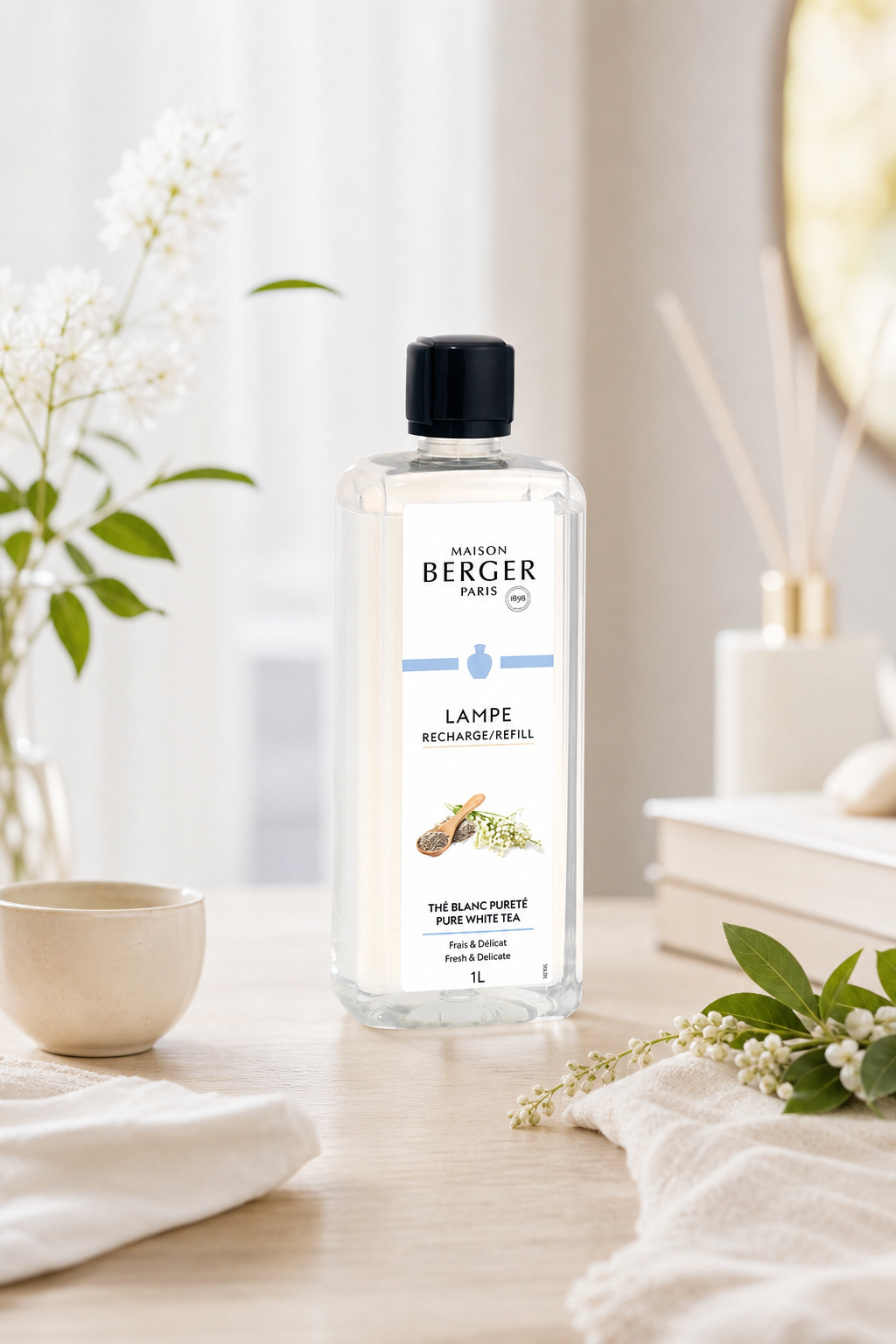 Maison Berger Pure White Tea Nachfüller auf einem Tisch neben Raumduftstäbchen