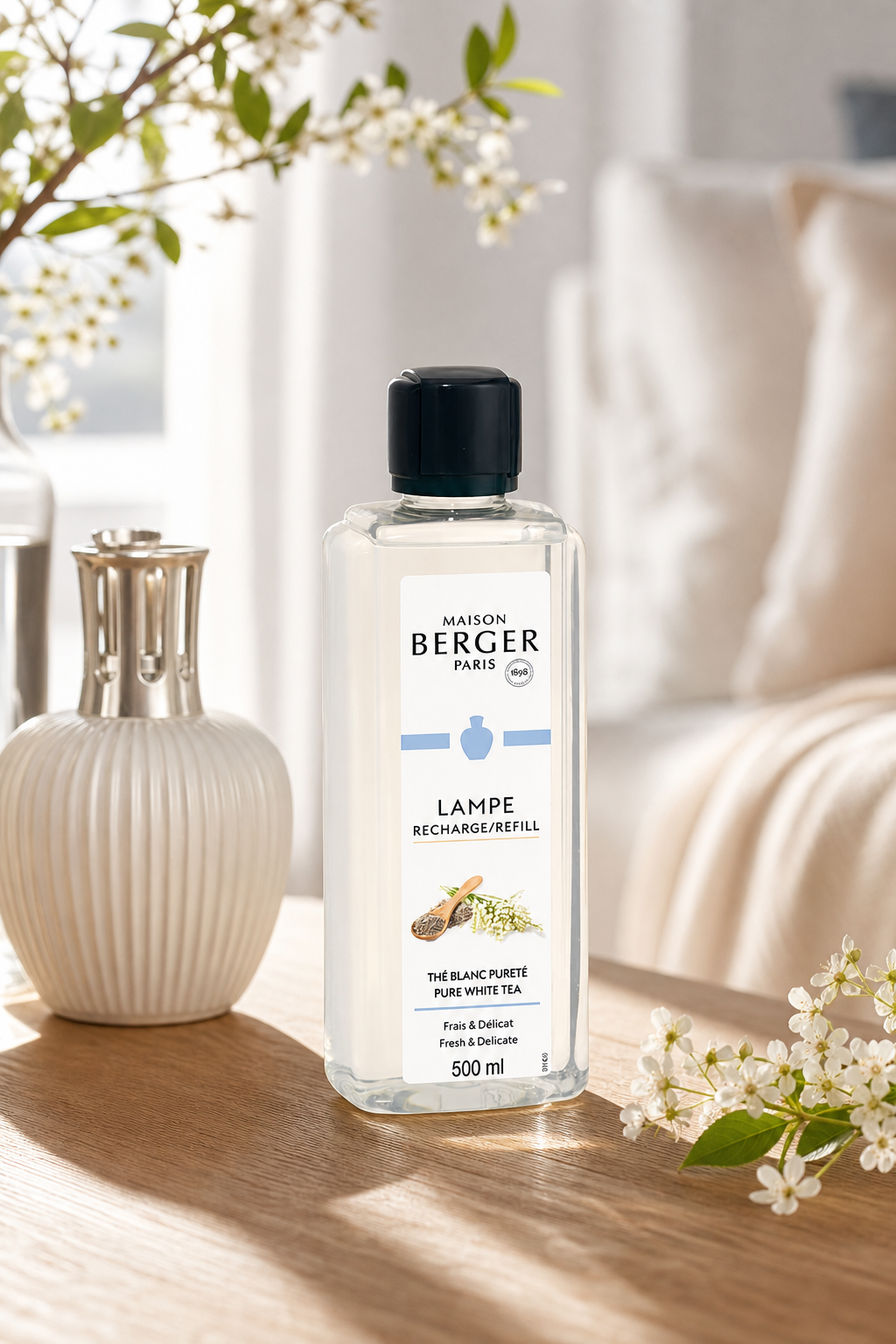 Maison Berger Nachfüllflasche Pure White Tea steht auf einem Holztisch neben einer Vase