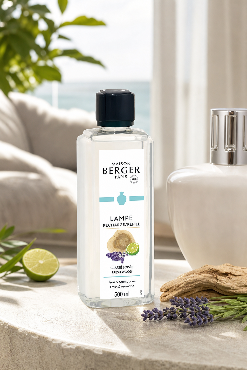 Maison Berger Nachfüllflasche mit Fresh-Wood-Etikett neben Limette, Holzscheiben und Lavendel