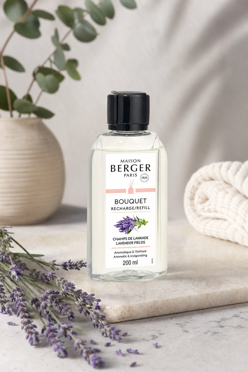 Lavendel-Nachfüllflasche auf Wohnaccessoires mit sichtbaren Lavendelzweigen