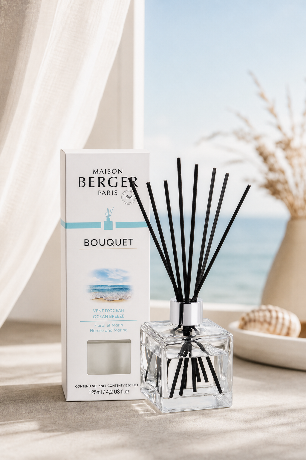 Raumduft-Diffuser mit Verpackung vor sichtbarem Meer im Hintergrund