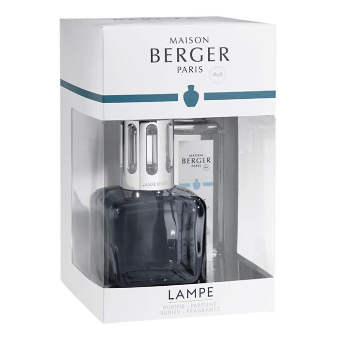 Lampe mit Schutzaufsatz neben Glaskrug und Teelöffel