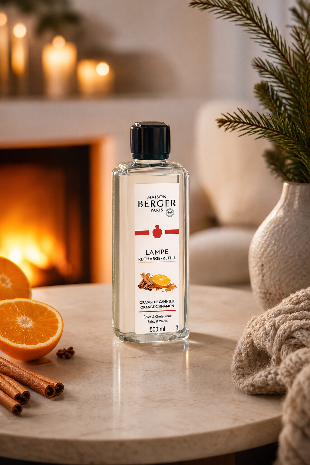Maison Berger Paris Lampen-Nachfüller Orange Cinnamon steht auf einem Tisch neben Orangen und Zimt