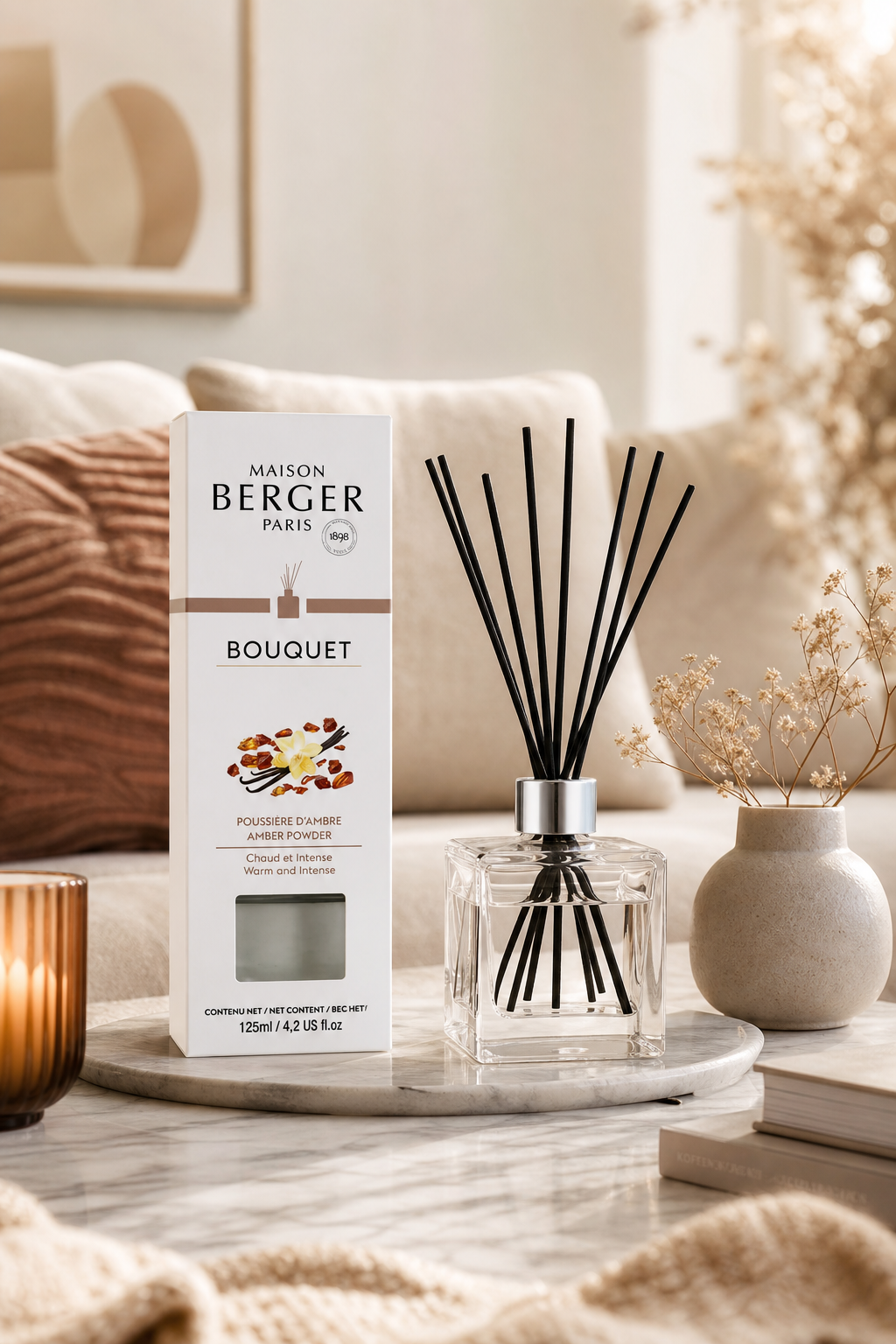 Raumduft-Diffuser mit schwarzen Stäbchen und Verpackung auf einem Wohnzimmertisch