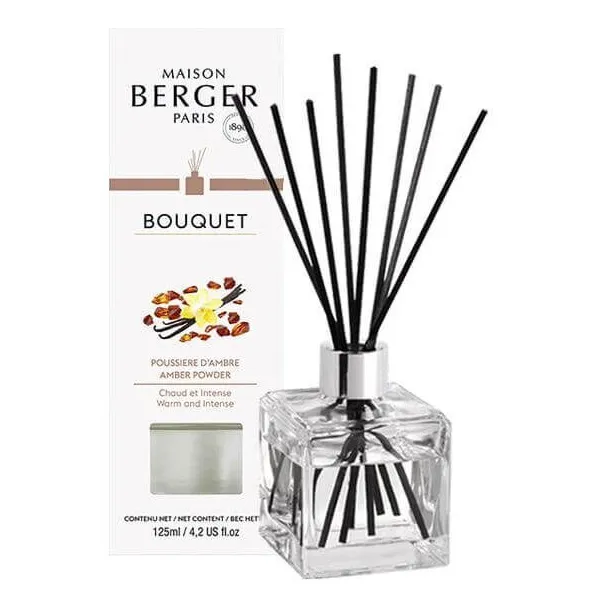 Diffuser mit Amber-Puderduft Glas-Diffuser mit schwarzen Duftstäbchen neben der Produktverpackung
