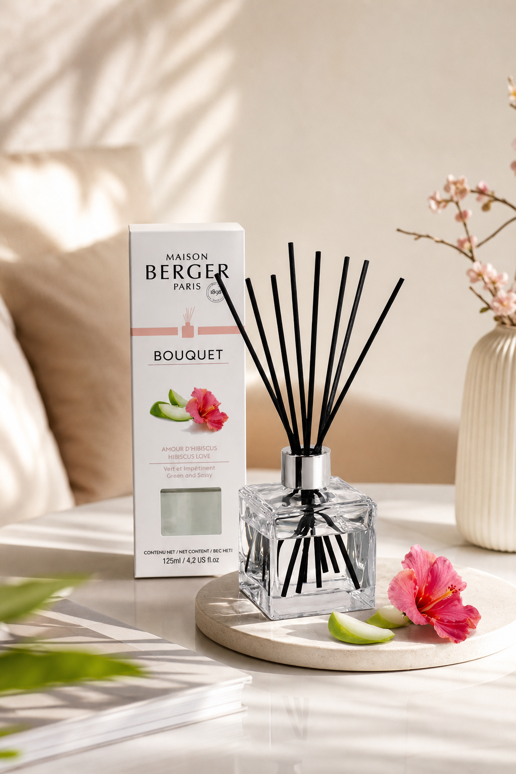 Hibiskus-Raumduft-Diffuser mit Verpackung auf einem Tisch neben Hibiskusblüten