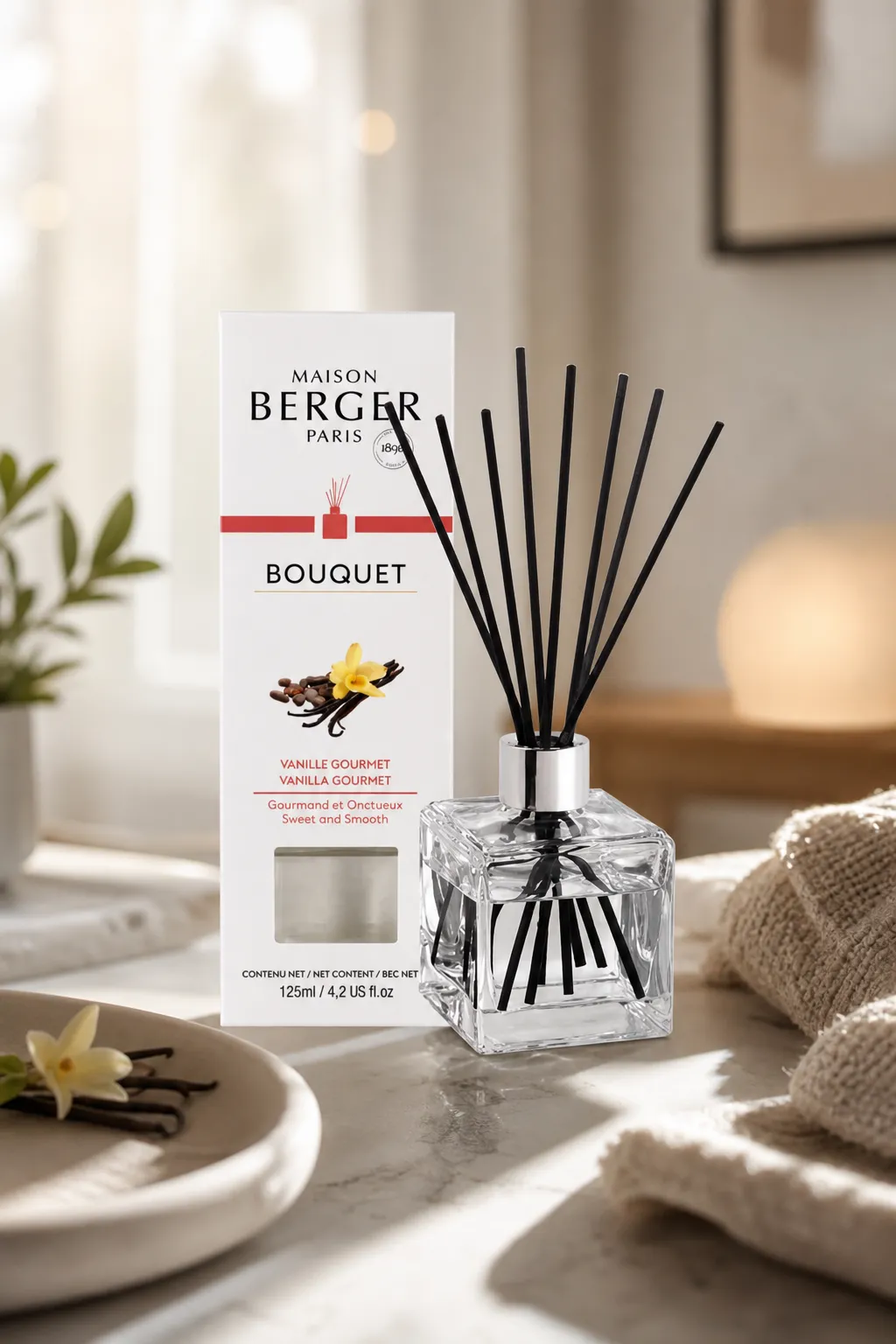 Vanille Gourmet Diffuser im Wohnambiente Maison Berger Paris Diffuser mit schwarzen Stäbchen auf einem Tisch im Wohnraum