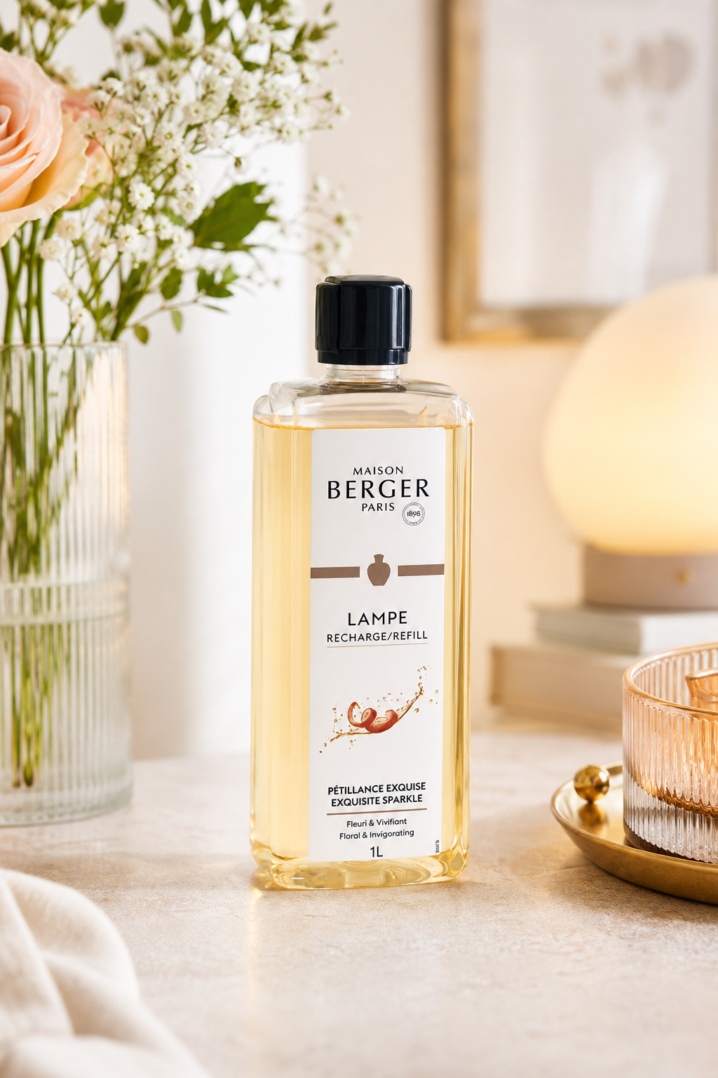 Maison Berger Nachfüllflasche steht auf einem Tisch neben Blumen und Wohnaccessoires