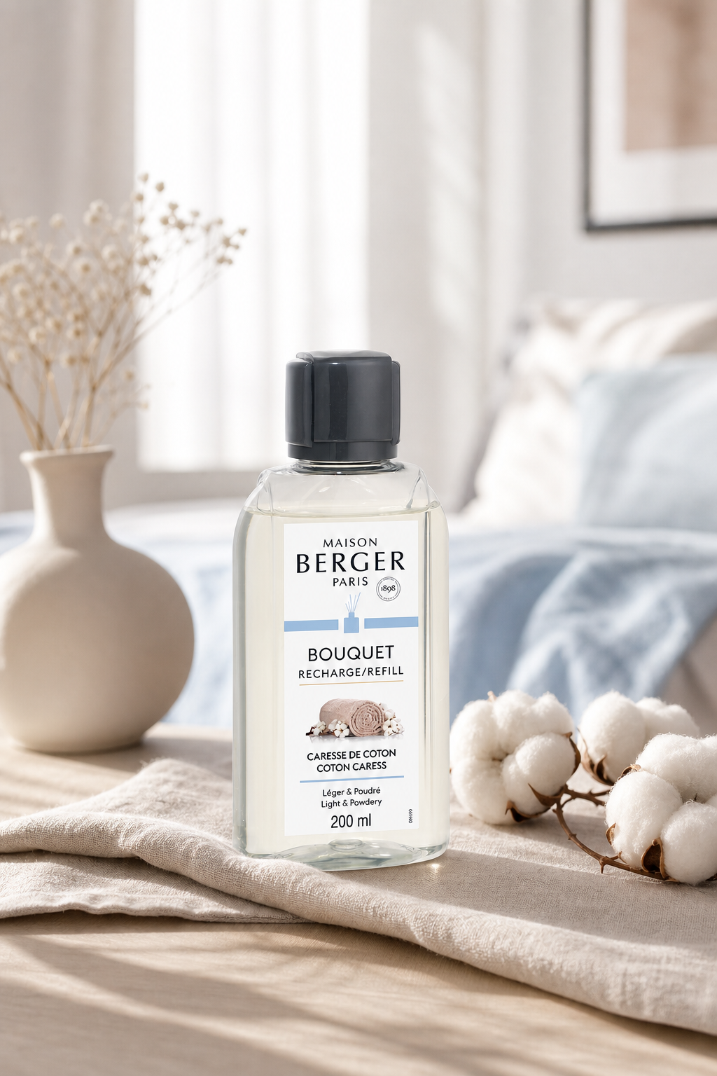 Maison Berger Nachfüller Caresse de Coton auf Tisch neben Baumwollblüten