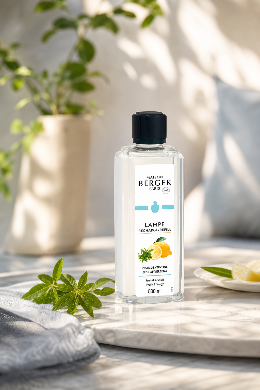 Maison Berger Nachfüllflasche mit Zitronen-Verbene neben Zitrone und grünen Blättern