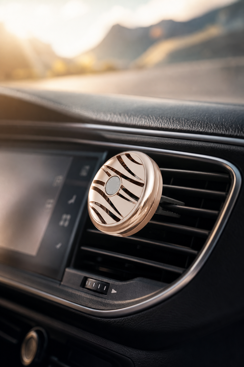 Roségoldener Autoduft-Diffuser steckt im Lüftungsgitter eines Autos