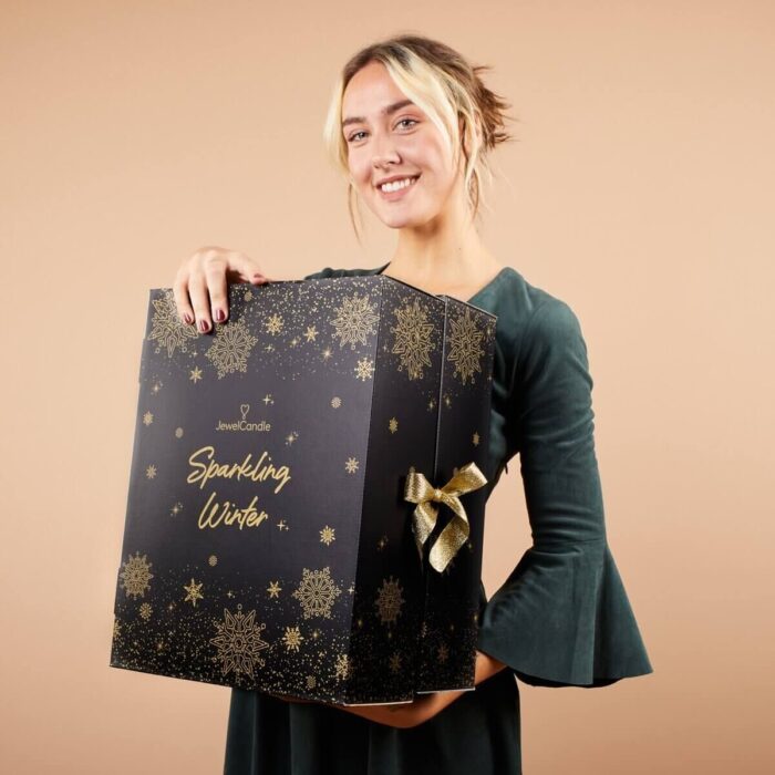 Frau präsentiert den geschlossenen JuwelCandle Sparkling Winter Adventskalender