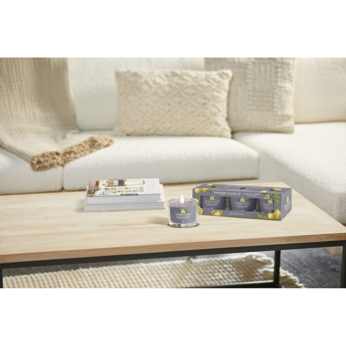 Angezündete Yankee Candle Kerze und Black Tea & Lemon Dreierpack auf Tisch