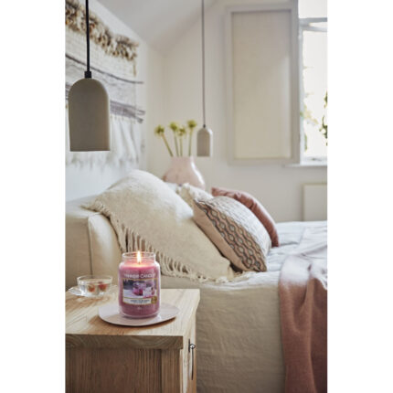 Brennende Yankee Candle Sweet Plum Sake Kerze auf einem Wohnzimmertisch