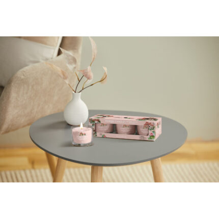 Brennende Yankee Candle Tranquil Garden Glasvotivkerze neben der Verpackung