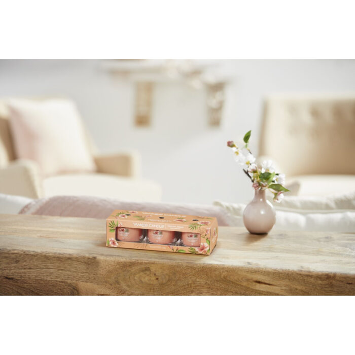 Dreierpack Tropical Breeze neben brennender Yankee Candle Glasvotivkerze