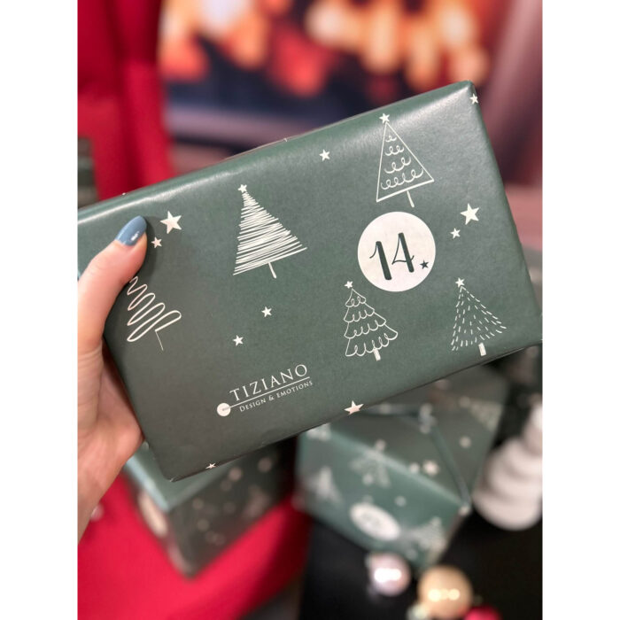 Gehaltene Tiziano Box mit Weihnachtsbaum-Motiven und der Nummer 14