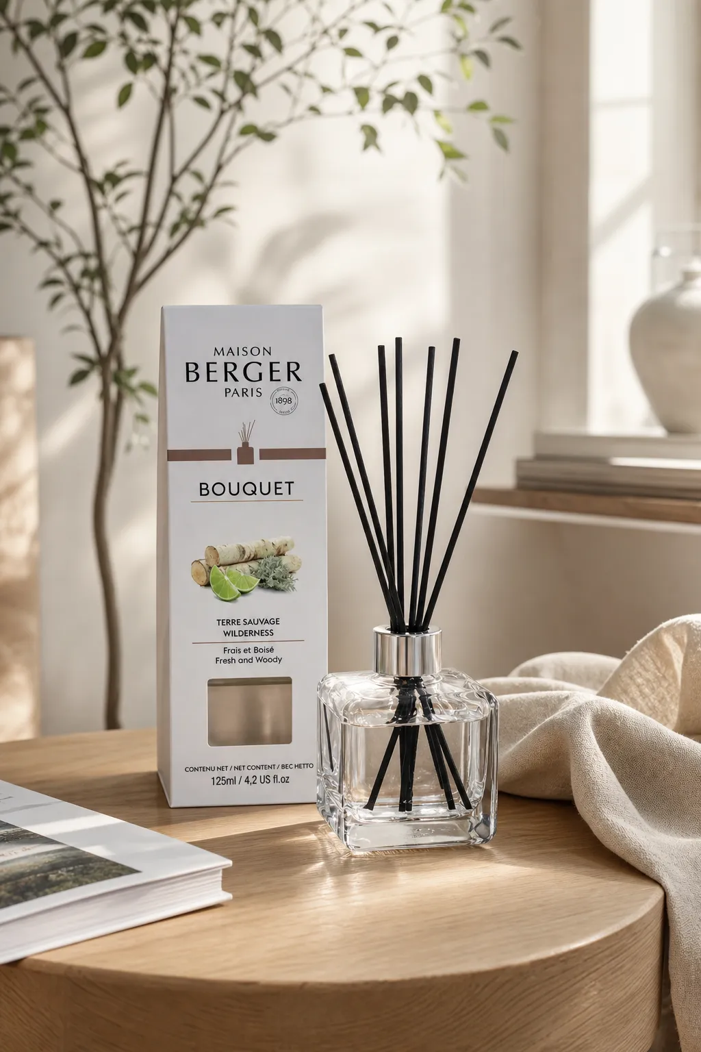 Diffuser im Wohnambiente Maison-Berger-Diffuser mit Duftstäbchen und Verpackung auf einem Holztisch