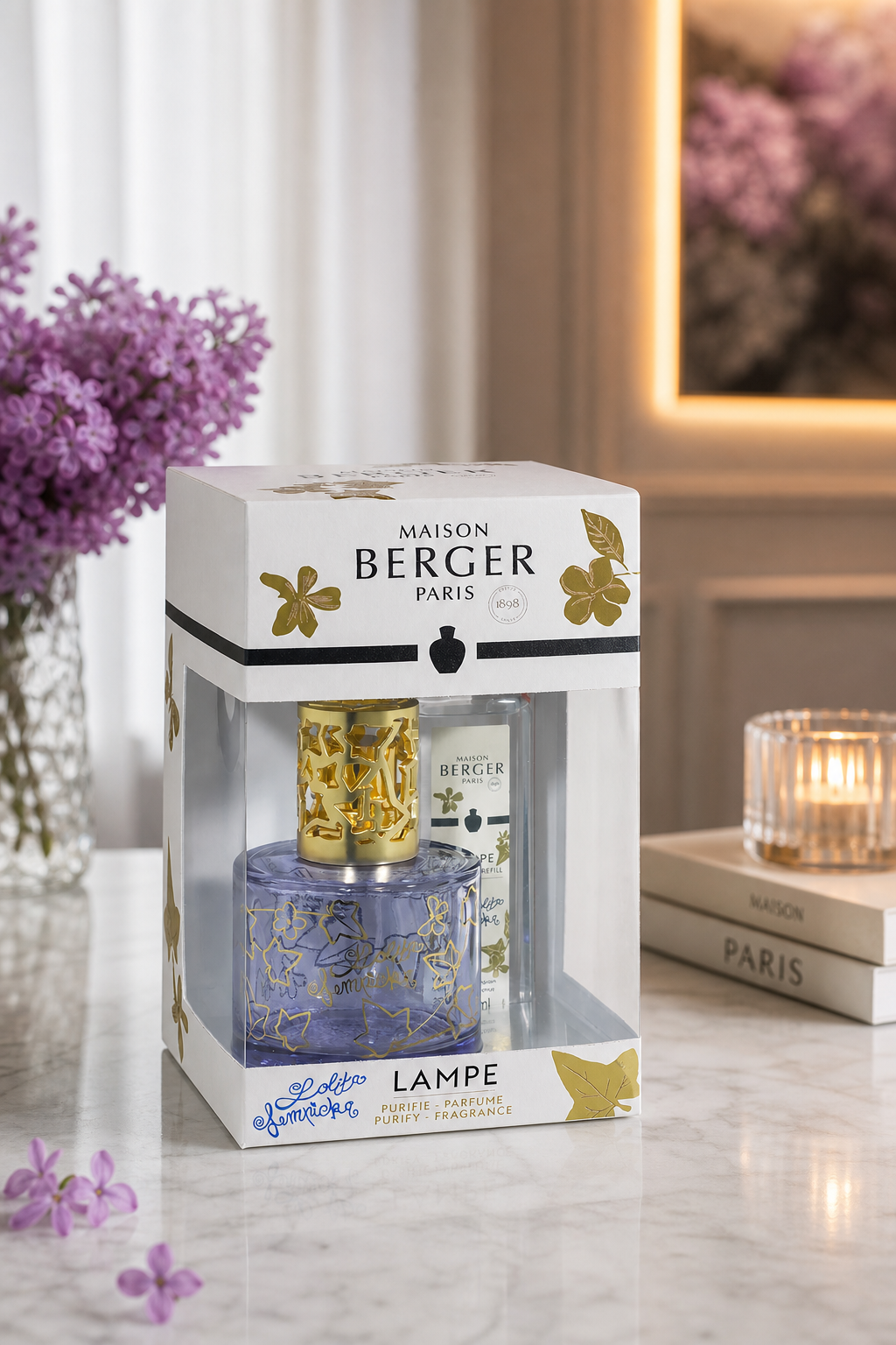 Verpacktes Maison Berger Paris Lampenset auf Tisch neben violetten Blumen