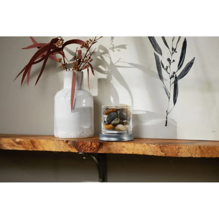 Dekorative Herbstszene mit Vase, Zweigen und Steinen im Glas