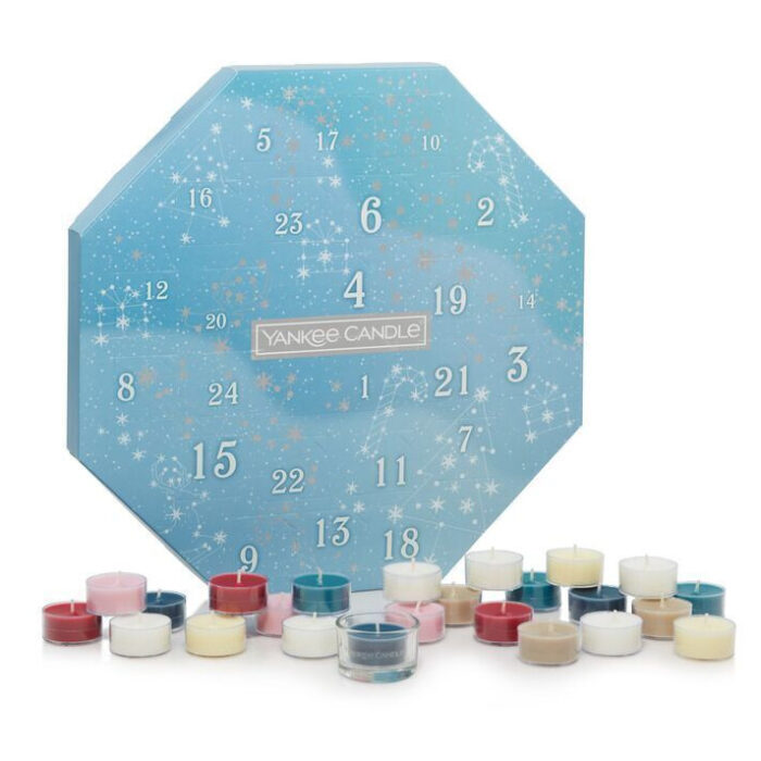 Yankee Candle Adventskalender neben Weihnachtsbaum und Teelichtkerzen