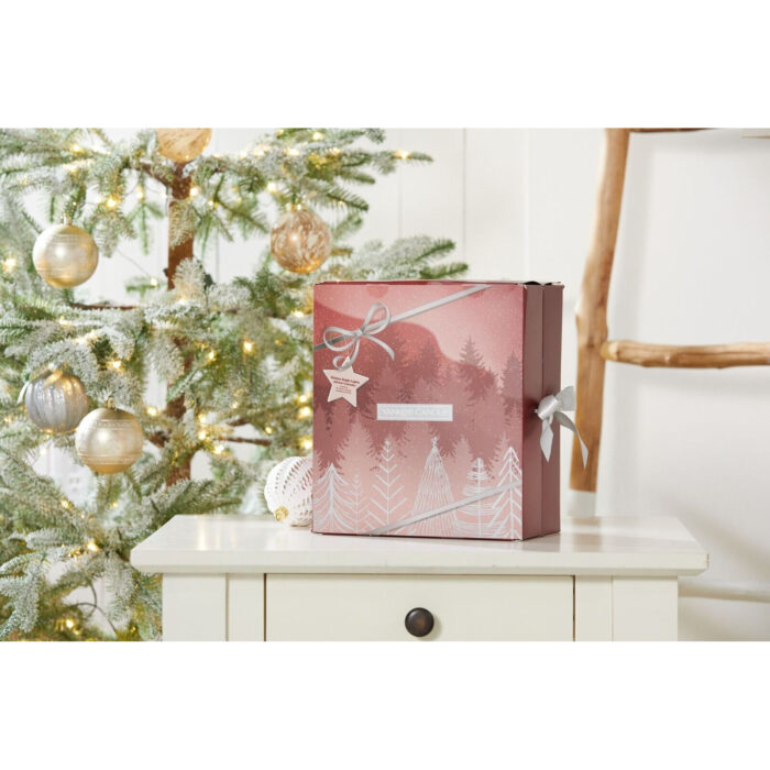 Geöffneter Adventskalender neben Weihnachtsdekoration auf einem Holztisch