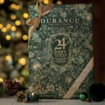 Durance Adventskalender mit 24 Duftkerzen und Schleifenband vor Weihnachtsdekoration