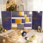 Geöffneter Adventskalender mit nummerierten Schachteln und weihnachtlicher Dekoration