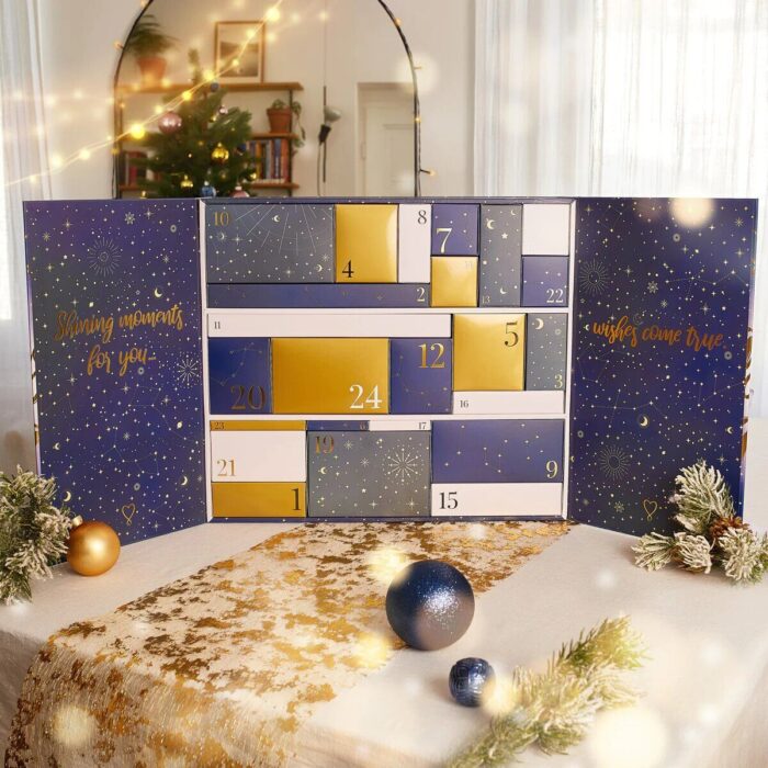 Geöffneter Adventskalender mit nummerierten Schachteln und weihnachtlicher Dekoration