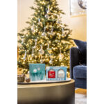 Yankee Candle Geschenkset steht vor einem beleuchteten Weihnachtsbaum