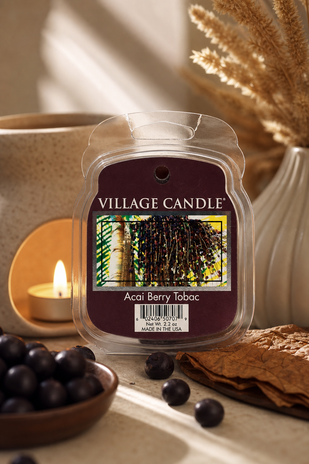 Village Candle Acai Berry Tobac Packung vor brennender Kerze und Beeren