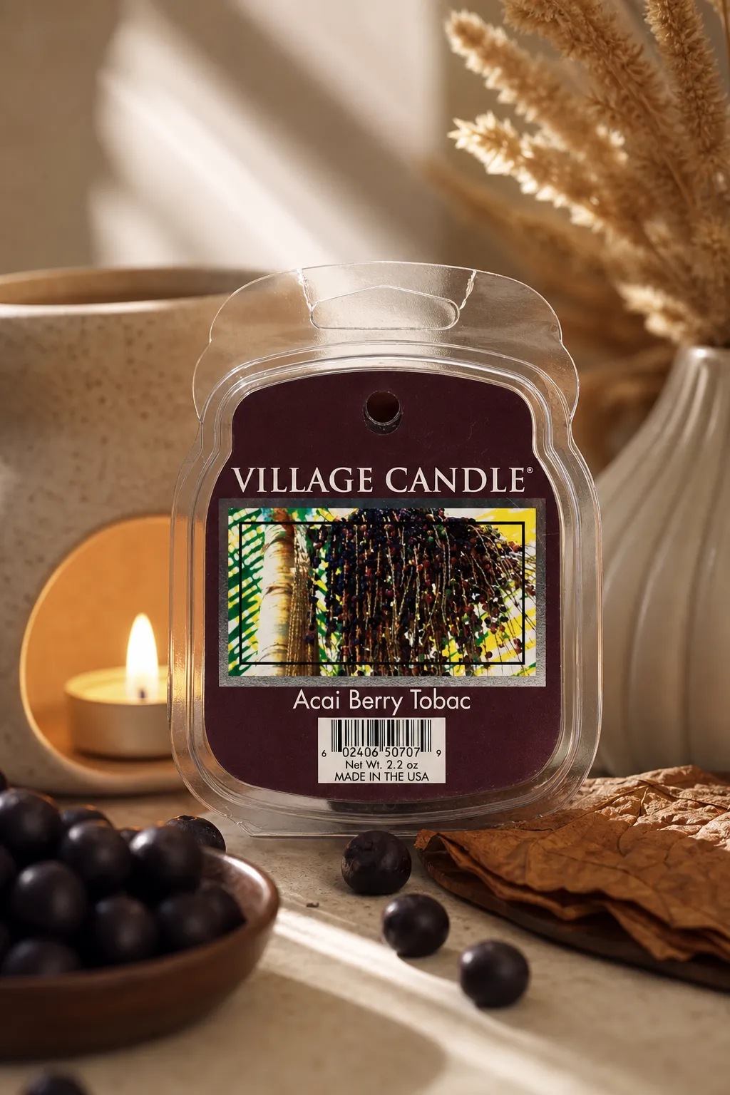 Village Candle Acai Berry Tobac Packung vor brennender Kerze und Beeren