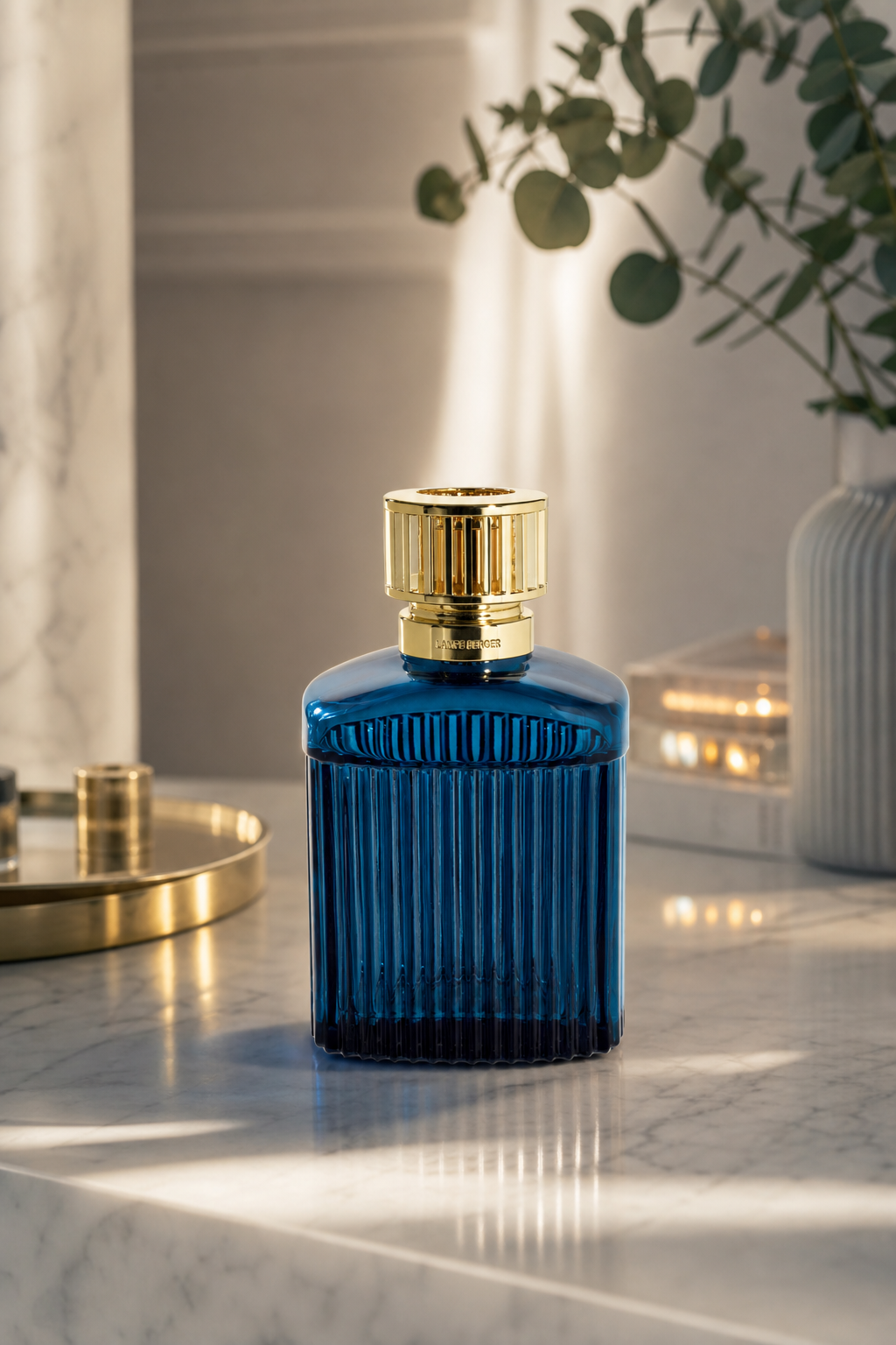 Blaue geriffelte Lampe mit goldener Kappe auf einer hellen Oberfläche