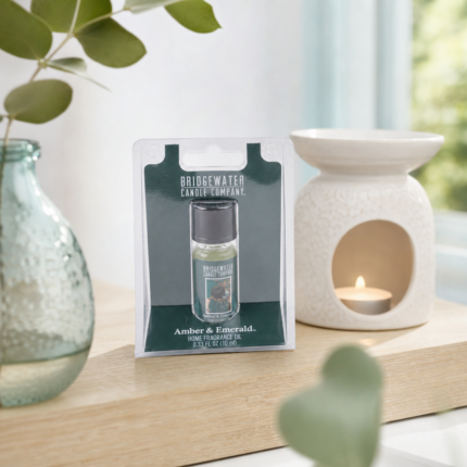 Verpacktes Bridgewater Amber & Emerald Home Fragrance Oil neben einer brennenden Duftlampe