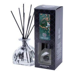 Amber & Emerald Reed Diffuser mit schwarzen Duftstäbchen neben Verpackung