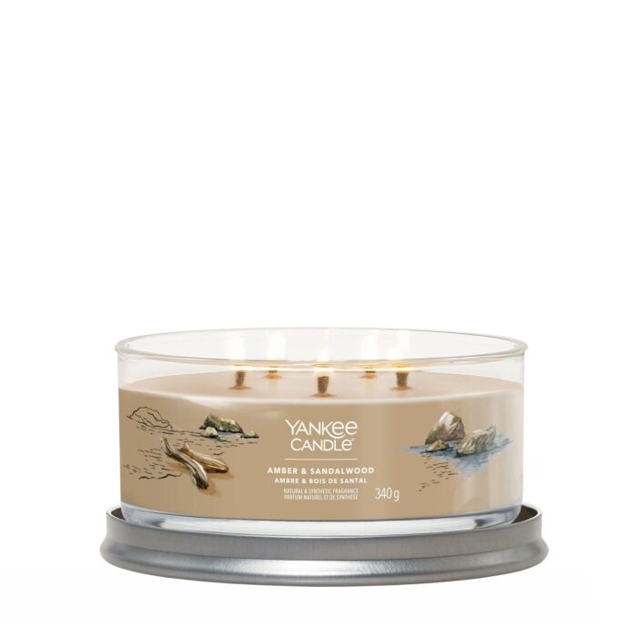 Brennende Yankee Candle Amber & Sandalwood Kerze auf rundem Kerzenhalter