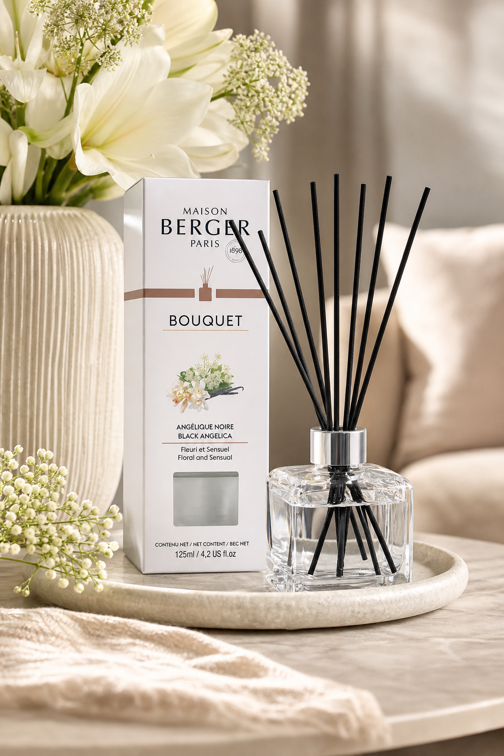 Angélique-Noire-Diffuser mit Verpackung auf einem Tablett neben Blumen