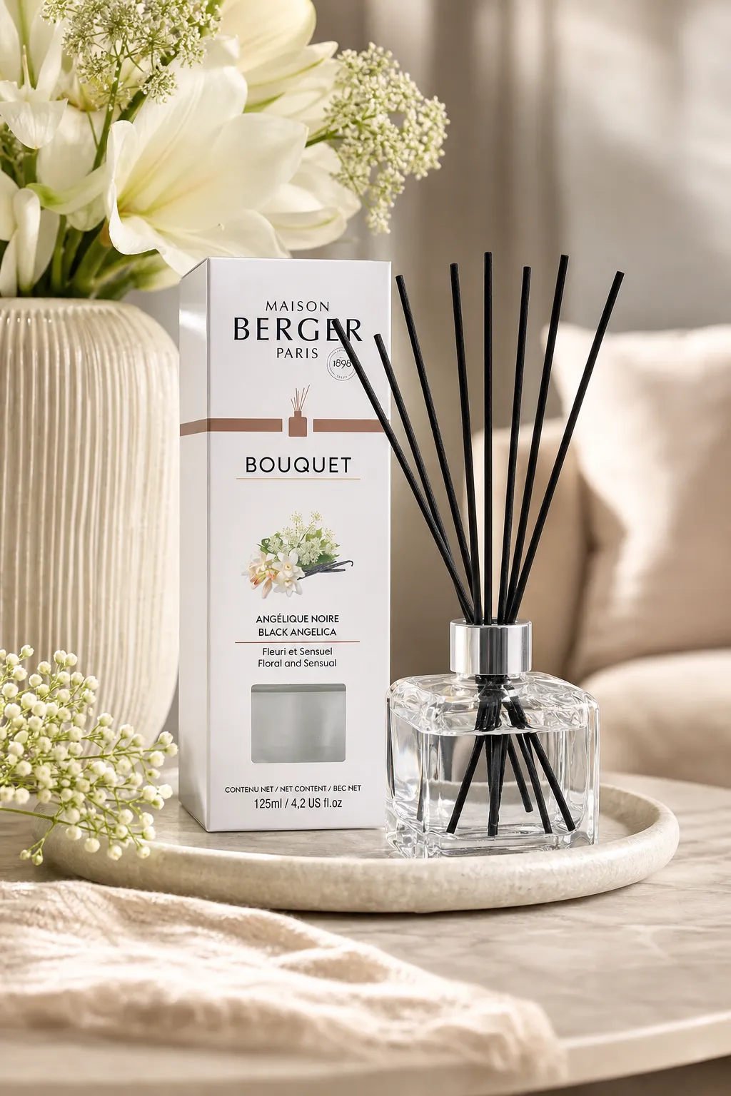 Diffuser im Wohnambiente Angélique-Noire-Diffuser mit Verpackung auf einem Tablett neben Blumen