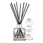 Transparenter Diffuser mit schwarzen Stäbchen neben geöffneter Maison Berger Bouquet Nachfüllflasche